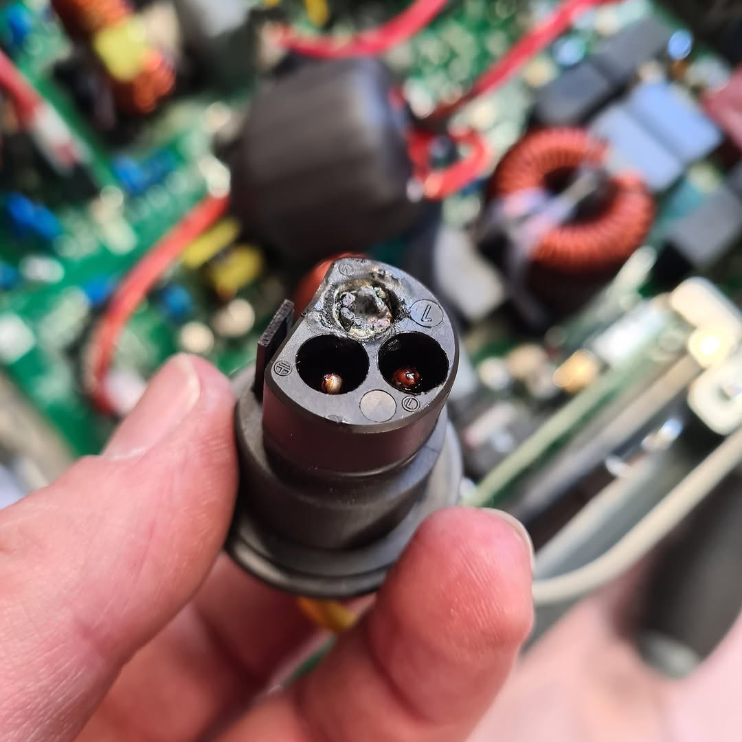 Beschädigter Stecker vor dem geöffneten Wechselrichter